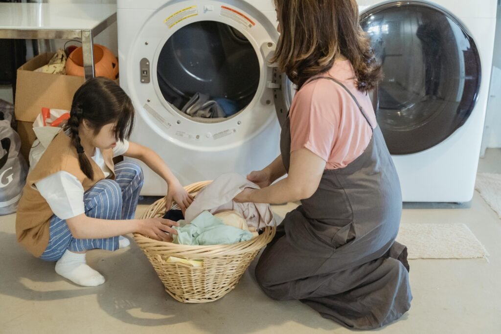 A mother and daughter sorting laundry together in a cozy home setting.